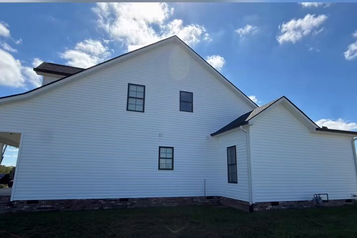 White vinyl siding on a home we washed, with dark window trim and a clean roofline
