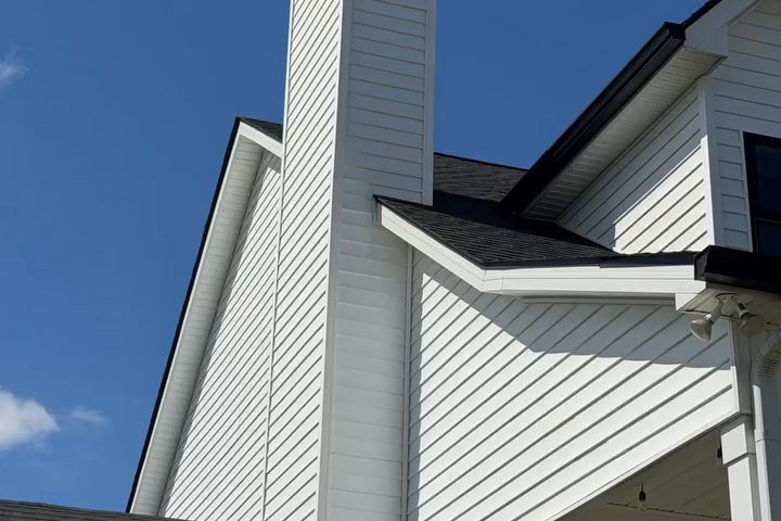 Three dormers on a clean white home with a dark shingled roof
